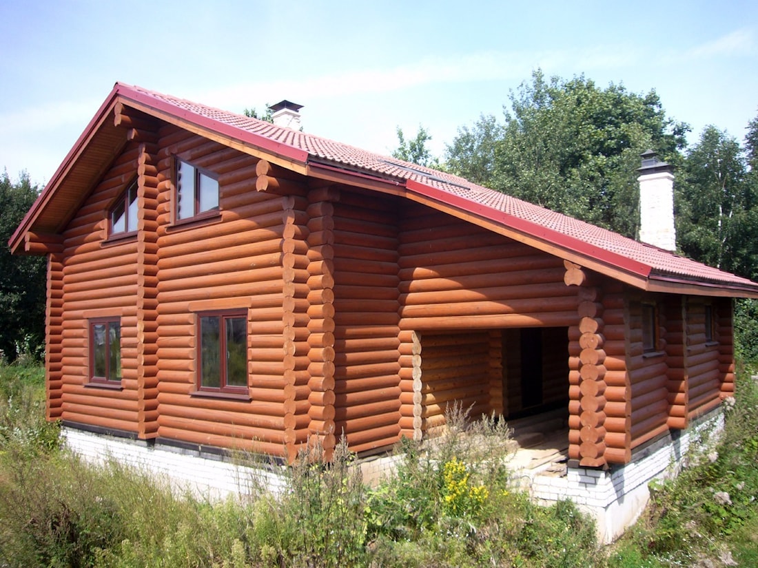 Log cabin design from round logs in a country style